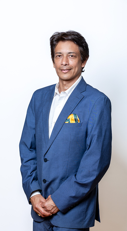 Executive headshot in a blue suit against a white backdrop